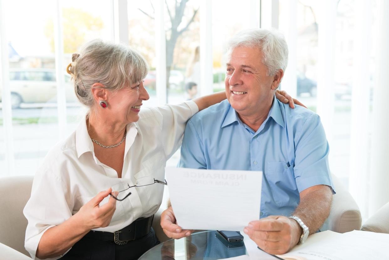 senior couple read the form for life insurance