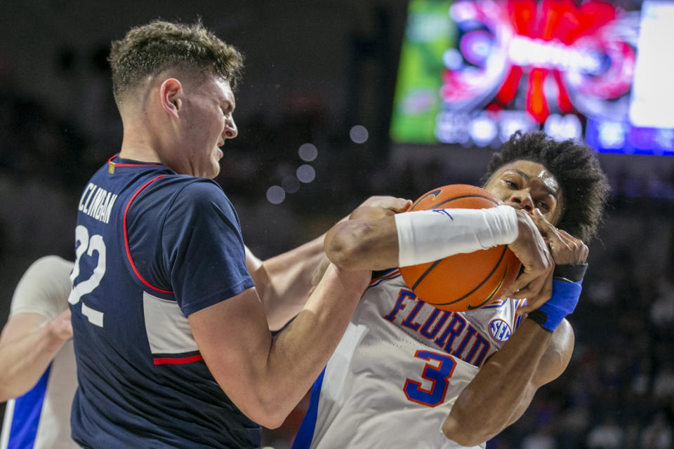 Connecticut center Donovan Clingan (32) wrestles with Florida forward Alex Fudge (3) for a rebound during the first half of an NCAA college basketball game Wednesday, Dec. 7, 2022, in Gainesville, Fla. (AP Photo/Alan Youngblood)