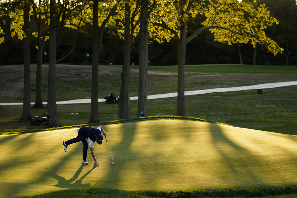 Justin Thomas, of the United States, marks his ball on the 18th green during the third round of the US Open Golf Championship, Saturday, Sept. 19, 2020, in Mamaroneck, N.Y. (AP Photo/Charles Krupa)