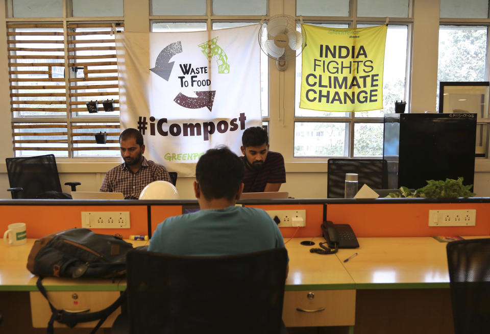 Banners are displayed on windows as employees work at Greenpeace India office in Bangalore, India, Tuesday, Feb. 5, 2019. International rights groups and foreign aid organizations with deep roots in India say they are struggling to operate under the administration of Prime Minister Narendra Modi, whose Hindu nationalist Bharatiya Janata Party has elevated the role of homegrown social groups while cracking down on foreign charities. (AP Photo/Aijaz Rahi)