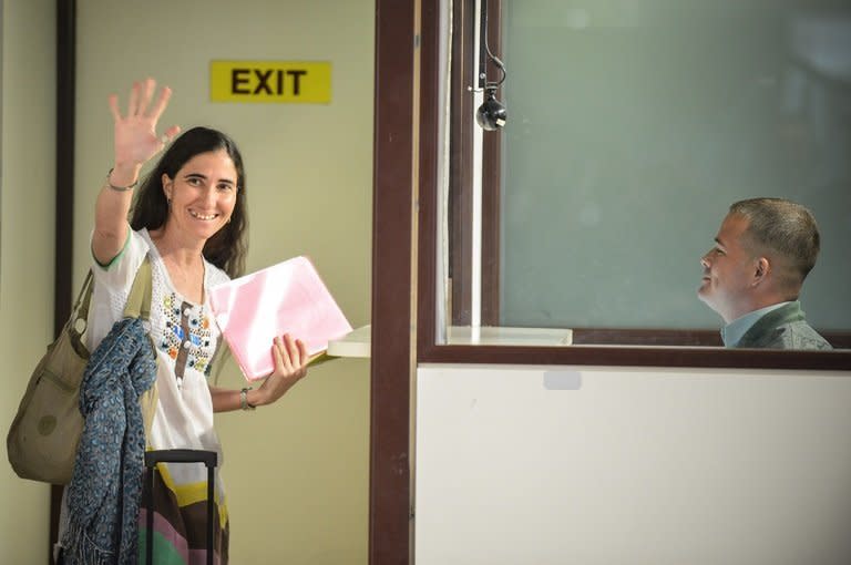 Cuban dissident blogger Yoani Sanchez waves goodbye at Havana's airport on February 17, 2013. She was allowed to embark on a three-month trip Sunday to Latin America, Europe and the United States