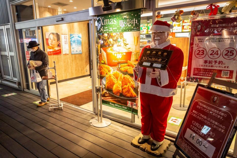 A man holding a Christmas meal box leaves a KFC restaurant on December 23, 2020 in Tokyo, Japan (Getty Images)