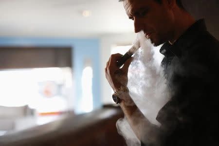 A man uses an electronic cigarette at The Vapor Spot vapor bar in Los Angeles, California March 4, 2014. REUTERS/Mario Anzuoni/Files