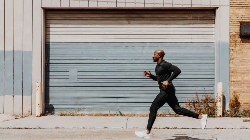 side view of man jogging in city