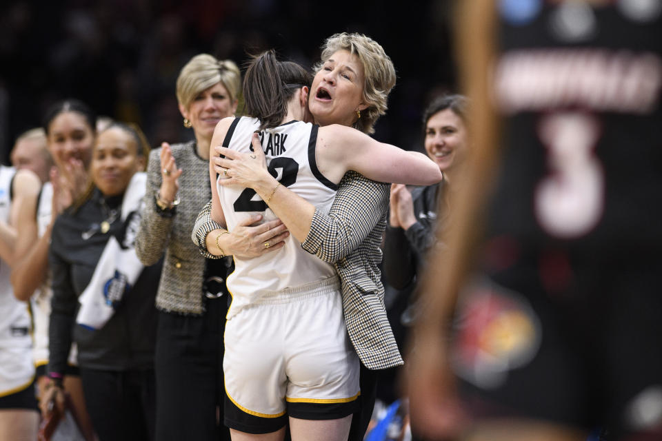 Iowa guard Caitlin Clark embraces head coach Lisa Bluder as she is subbed out of the game in the second half of an Elite 8 college basketball game of the NCAA Tournament against Louisville, Sunday, March 26, 2023, in Seattle. (AP Photo/Caean Couto)