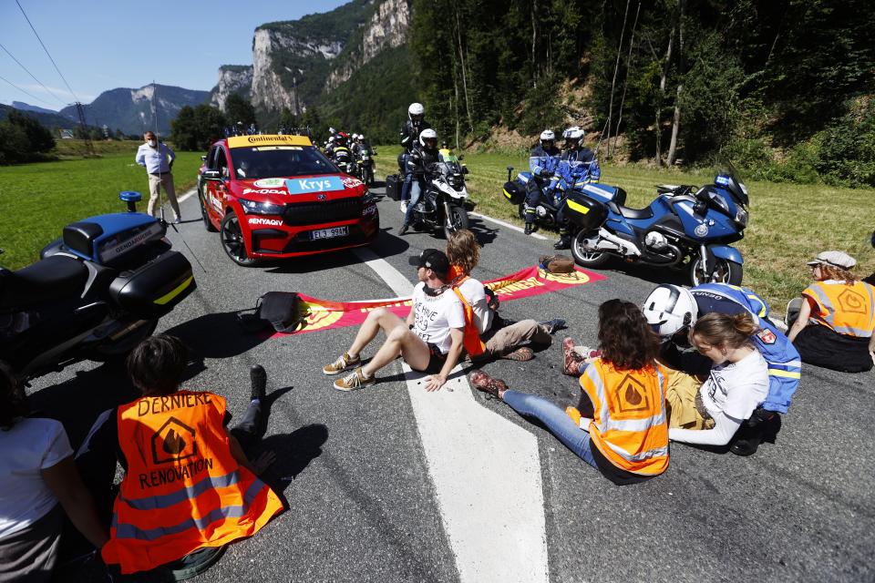 Protestors sit on the road during the 10th stage of the Tour de France (EPA)