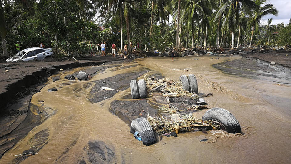 The remains of a truck is submerged in mudflow from Mayon Volcano triggered by heavy rains from Typhoon Goni in the town of Guinobatan, Albay province, central Philippines on Monday, Nov. 2, 2020. More than a dozen people were killed as Typhoon Goni lashed the Philippines over the weekend, and about 13,000 shanties and houses were damaged or swept away in the eastern island province that was first hit by the ferocious storm, officials said Monday. (AP Photo)