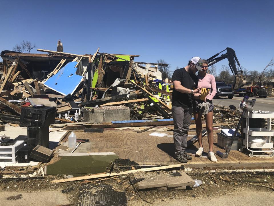 Two people stand in front of a destroyed business in Wynne, Ark., on Saturday, April 1, 2023. Unrelenting tornadoes that tore through parts of the South and Midwest that shredded homes and shopping centers. (AP Photo/Adrian Sainz)