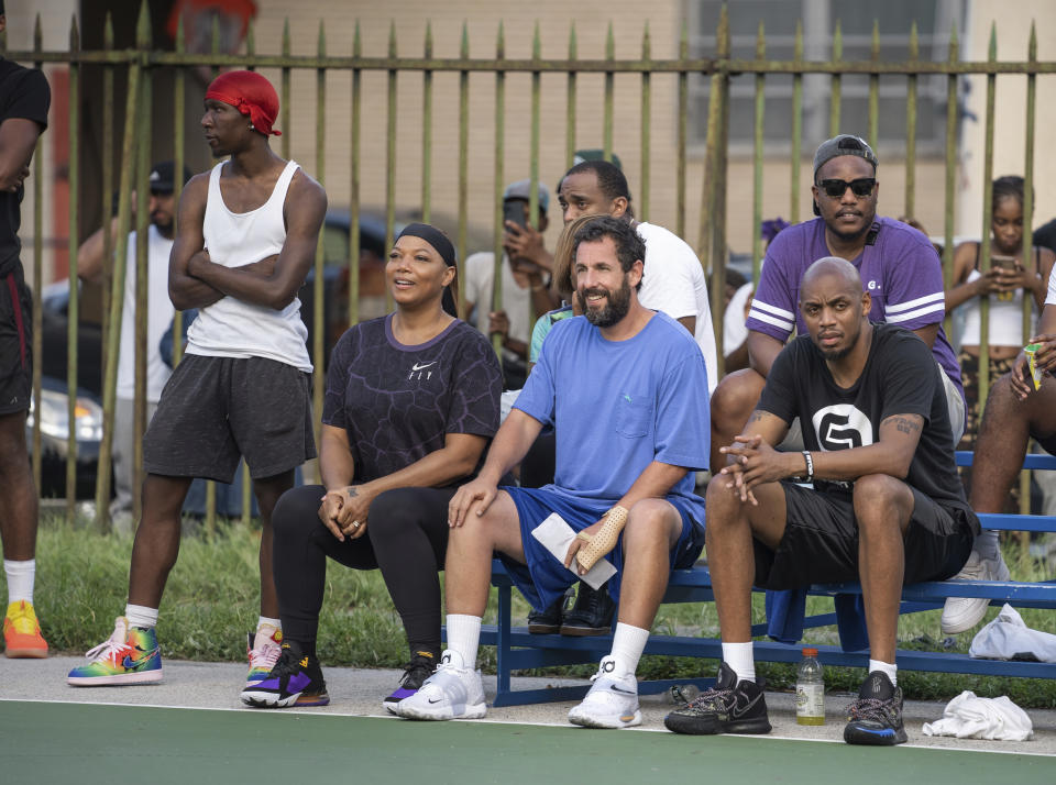 This image released by Netflix shows Queen Latifah, seated from left, and Adam Sandler in a scene from "Hustle." (Scott Yamano/Netflix via AP)