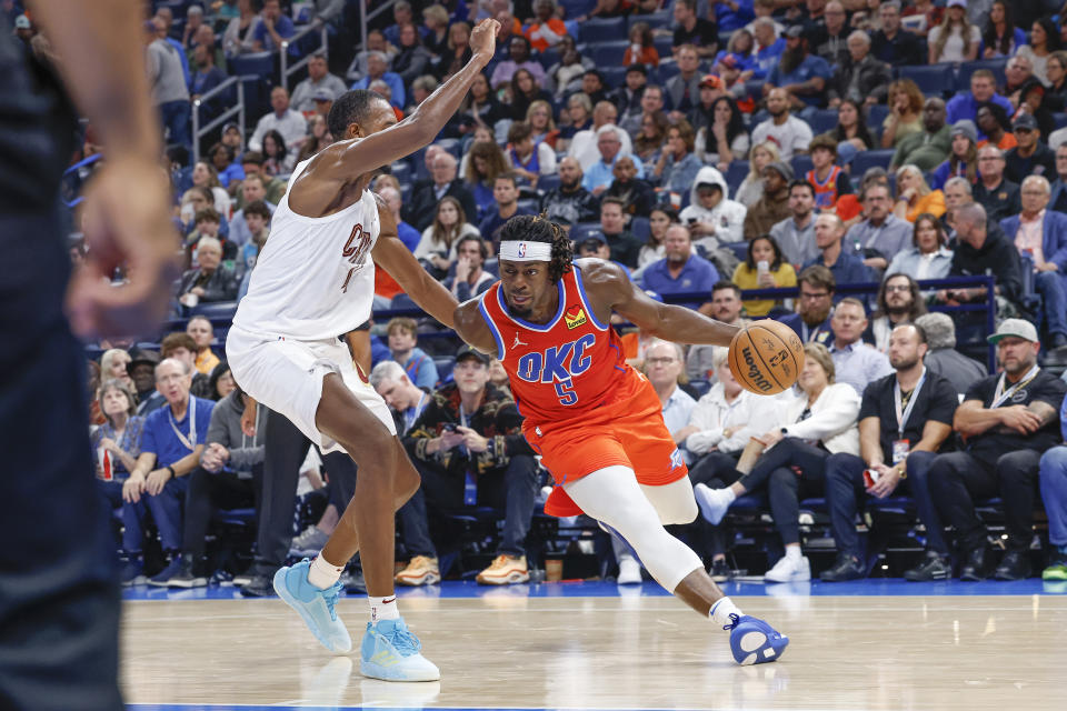 Nov 8, 2023; Oklahoma City, Oklahoma, USA; Oklahoma City Thunder guard Luguentz Dort (5) drives around Cleveland Cavaliers forward Evan Mobley (4) during the second half at Paycom Center. Oklahoma City won 128-120. Mandatory Credit: Alonzo Adams-USA TODAY Sports