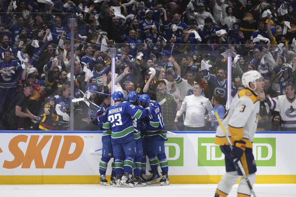 Nashville Predators defenseman Jeremy Lauzon (3) skates away as Vancouver fans and players celebrate a goal by Canucks center Dakota Joshua (81) during the third period in Game 1 of an NHL hockey Stanley Cup first-round playoff series in Vancouver, British Columbia, on Sunday, April 21, 2024. (Darryl Dyck/The Canadian Press via AP)