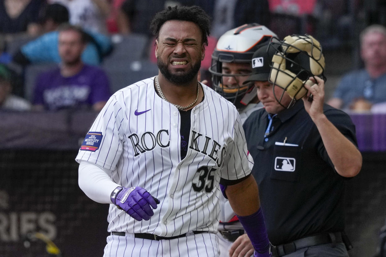 Colorado Rockies catcher Elias Díaz grimaces after he was hit by a pitch during the third inning of a baseball game against the the Houston Astros at the Alfredo Harp Helu stadium in Mexico City, Saturday, April 27, 2024. (AP Photo/Fernando Llano)