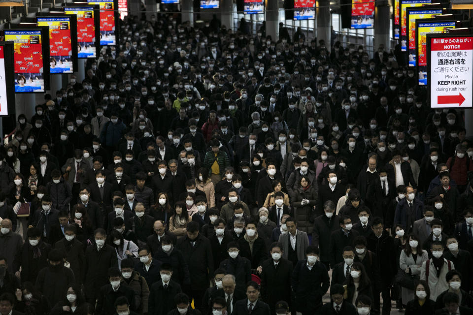 FILE - A large crowd of mask-wearing commuters walk through Shinagawa Station in Tokyo, on March 3, 2020. Wages are rising in Japan more than they have in decades, at least for some workers. But so are prices, leaving many people feeling they must scrimp more than ever. (AP Photo/Jae C. Hong, File)