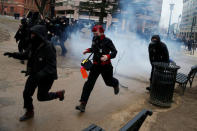 Activists race after being hit by a stun grenade while protesting against U.S. President-elect Donald Trump on the sidelines of the inauguration in Washington, U.S., January 20, 2017. REUTERS/Adrees Latif