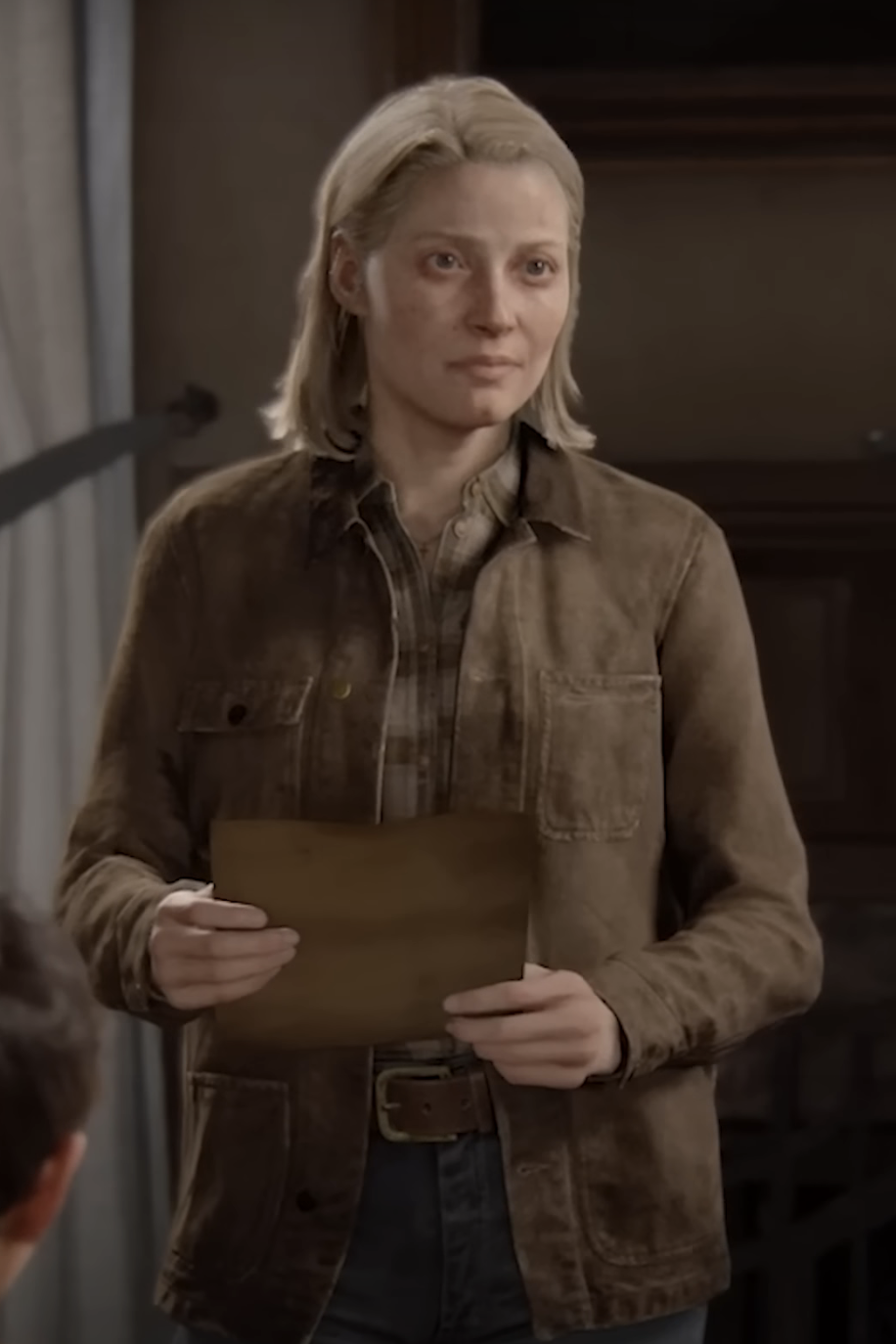 Maria in The Last of Us Part II holding an envelope, wearing a brown jacket and shirt on a TV set