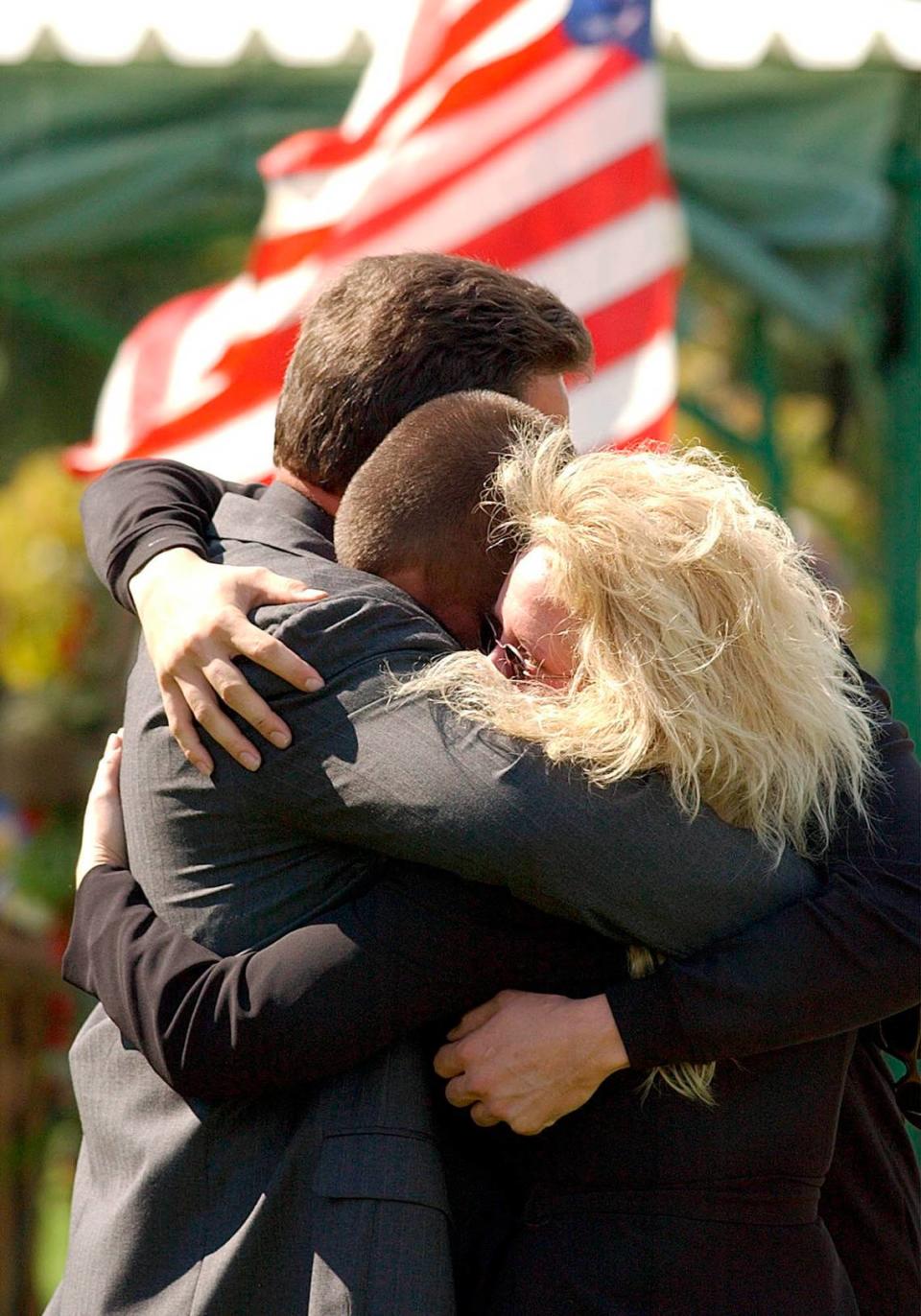 Frank Slanovits, cousin of Staff Sgt. Fred Miller who was killed in Iraq last week, hugs his son Joshua and girlfriend Alexis Berrier at the Brigadier General William C. Doyle Veteran’s Memorial Cemetery in Wrightstown, New Jersey, on Sept. 29, 2003.