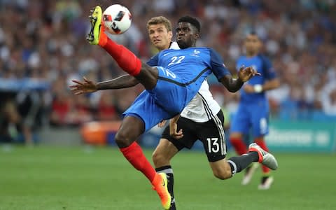 France's Samuel Umtiti hits a ball in front of Germany's Thomas Mueller during the Euro 2016 semifinal soccer match between Germany and France. - Credit: AP