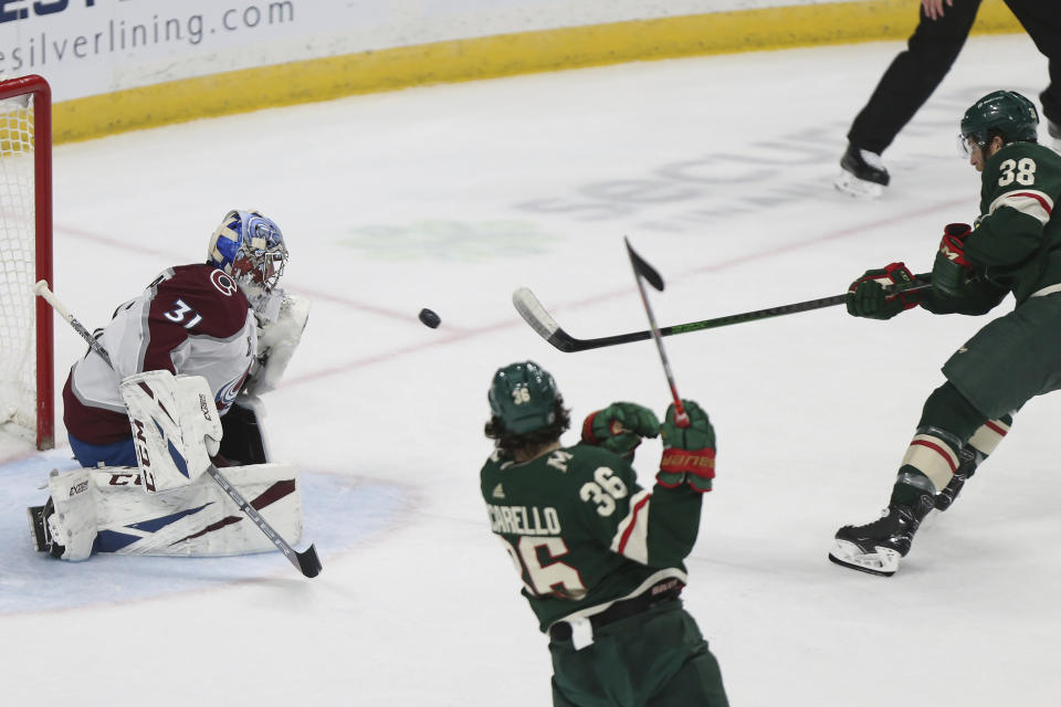 Minnesota Wild's Ryan Hartman (38) shoots the puck at Colorado Avalanche's goalie Philipp Grubauer (31) during the first period of an NHL hockey game Wednesday, April 7, 2021, in St. Paul, Minn. (AP Photo/Stacy Bengs)