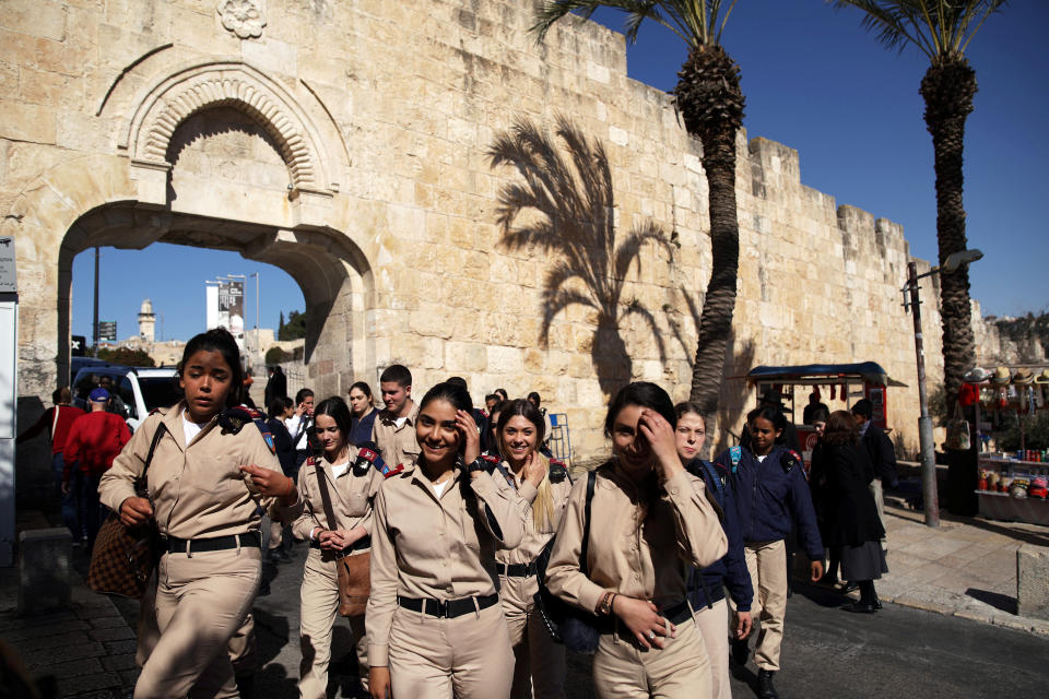 A group of female Israeli soldiers smile as they walk near Dung Gate in Jerusalem's Old City. (Photo: Nir Elias/Reuters)