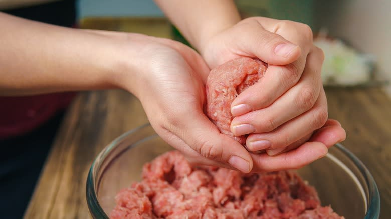 Woman mixing ground beef with hands