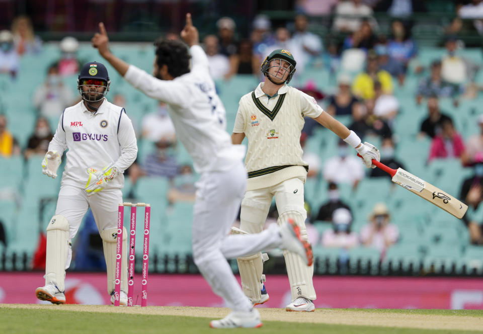 Australia's Marnus Labuschagne, right, reacts after he was dismissed off the bowling of India's Ravindra Jadeja, centre, during play on day two of the third cricket test between India and Australia at the Sydney Cricket Ground, Sydney, Australia, Friday, Jan. 8, 2021. (AP Photo/Rick Rycroft)