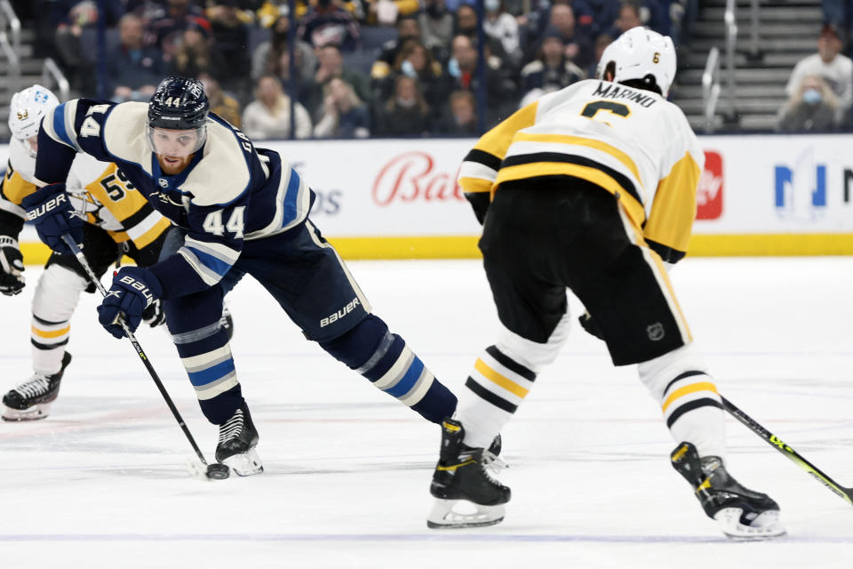 Columbus Blue Jackets' Vladislav Gavrikov, left, carries the puck across the blue line as Pittsburgh Penguins' John Marino defends during the second period of an NHL hockey game Sunday, Feb. 27, 2022, in Columbus, Ohio. (AP Photo/Jay LaPrete)