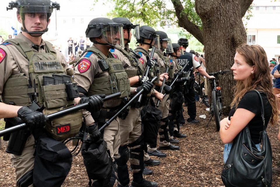 PHOTO: A student quietly stares at a row of Texas State Troopers as pro-Palestinian students protest the Israel-Hamas war on the campus of the University of Texas in Austin, Texas, on April 24, 2024. (Suzanne Cordeiro/AFP via Getty Images)