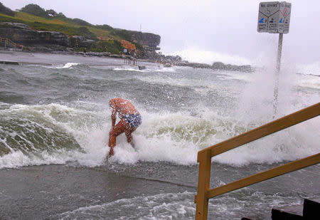 A swimmer is hit by a wave as he enters the water as severe weather, bringing strong winds and heavy rain, hits the eastern coast of Australia at Clovelly Beach in Sydney, June 5, 2016. REUTERS/David Gray