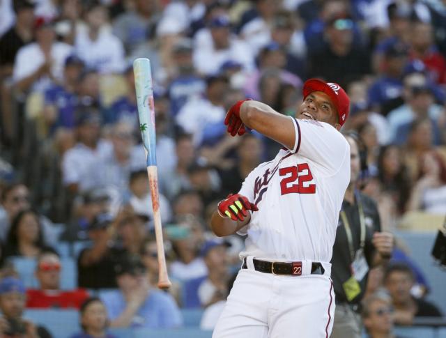 Washington Nationals' Juan Soto, front, stands in the dugout