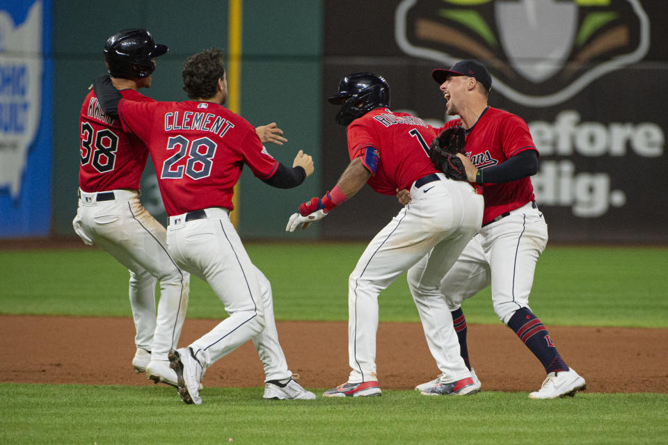 El dominicano Amed Rosario (1), de los Guardianes de Cleveland, es felicitado tras anotar en un error para conseguir la victoria en el segundo juego de una doble cartelera frente a los Mellizos de Minnesota (AP Foto/Phil Long)