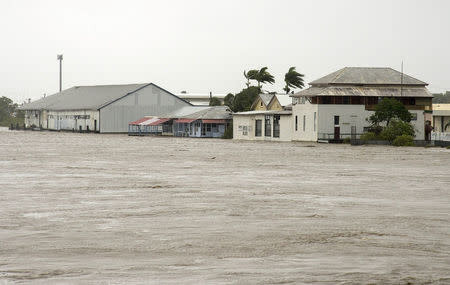 Buildings can be seen near the flooded Pioneer River after Cyclone Debbie hit the region in the northern Queensland town of Mackay in Australia, March 29, 2017. AAP/Daryl Wright/via REUTERS