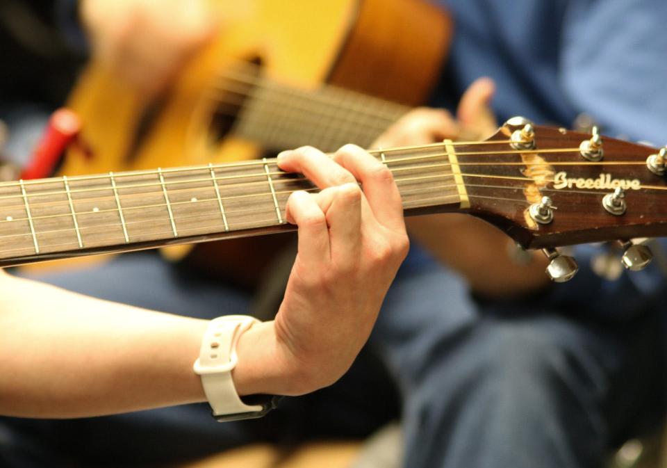 A student in Salina South Middle School's advanced guitar class plays a G Chord.