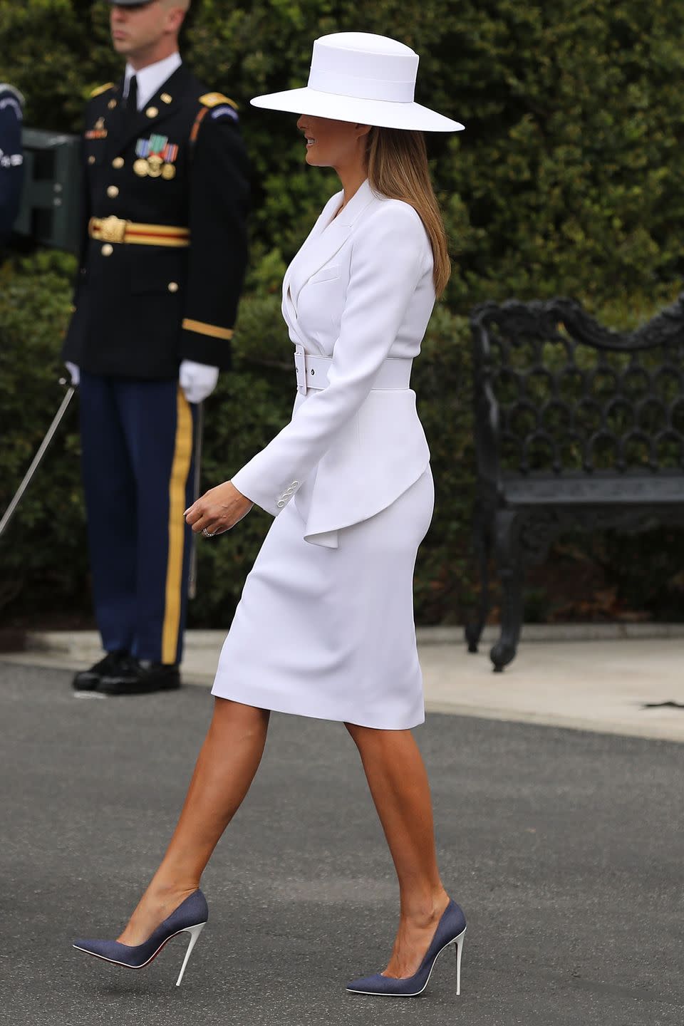 <p>Melania turned heads in this modern white ensemble! She wore an asymmetrical Michael Kors blazer and coordinating pencil skirt, Christian Louboutin pumps, and a wide-brimmed hat to greet President Emmanuel Macron and his wife, Brigitte. </p>