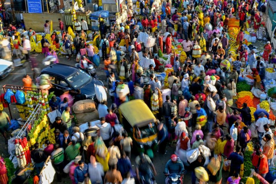 A large crowd of people walk through a market in Bangalore on October 23, 2022.<span class="copyright">Manjunath Kiran—AFP/Getty Images</span>