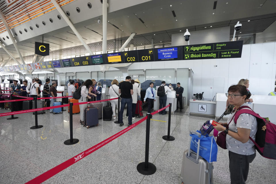 Tourists line up for check-in before departure at International Airport in Siem Reap province, Cambodia as it opened Thursday, Nov. 16, 2023. The new airport can handle 7 million passengers a year, with plans to augment it to handle 12 million passengers annually from 2040. It was constructed under a 55-year build-operate-transfer (BOT) program between Cambodia and China. (AP Photo/Heng Sinith)