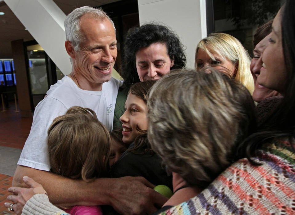 Alvin Schlangen, left, receives a group hug from his supporters after he was found not guilty in the raw-milk trial, on Thursday, Sept. 20, 2012 in Minneapolis. Schlangen, an organic egg producer in central Minnesota, was charged with three misdemeanor counts including distributing unpasteurized milk, operating without a food handler's license and handling adulterated food. Minnesota law prohibits raw milk sales except directly to consumers on the farm when it's produced. (AP Photo/The Star Tribune, Bruce Bisping)