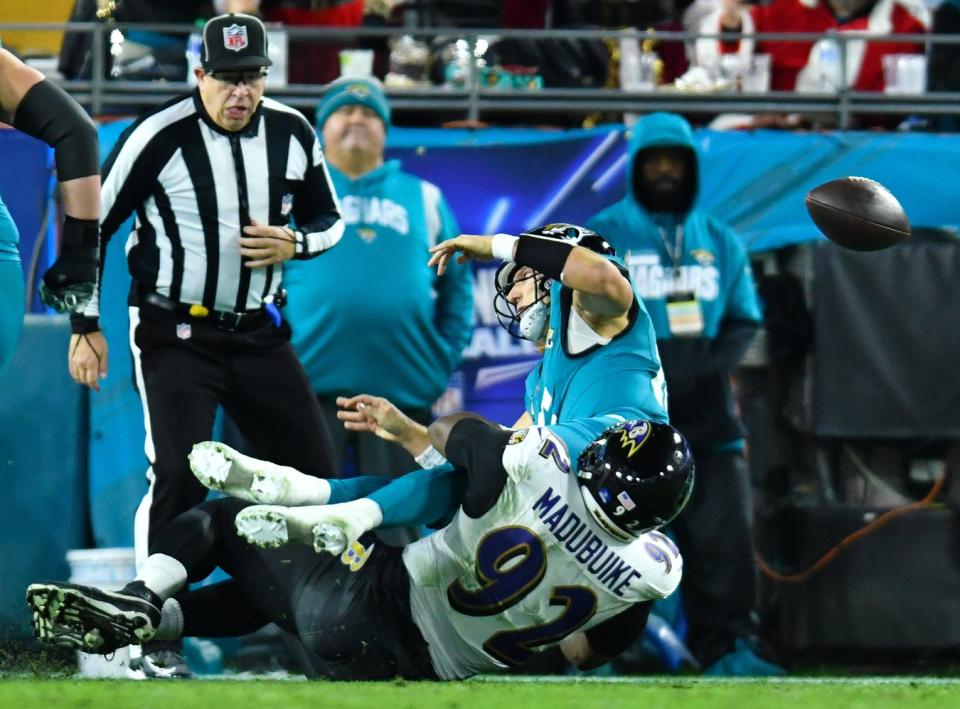 Jacksonville Jaguars quarterback Trevor Lawrence (16) throws the ball as he is tackled by Baltimore Ravens defensive tackle Justin Madubuike (92) late in the third quarter. Lawrence was called for intentional grounding on the play. The Jacksonville Jaguars hosted the Baltimore Ravens at EverBank Stadium in Jacksonville, Florida Sunday Night, December 17, 2023. The Jaguars trailed 10 to 0 at the half and lost 23 to 7. [Bob Self/Florida Times-Union]