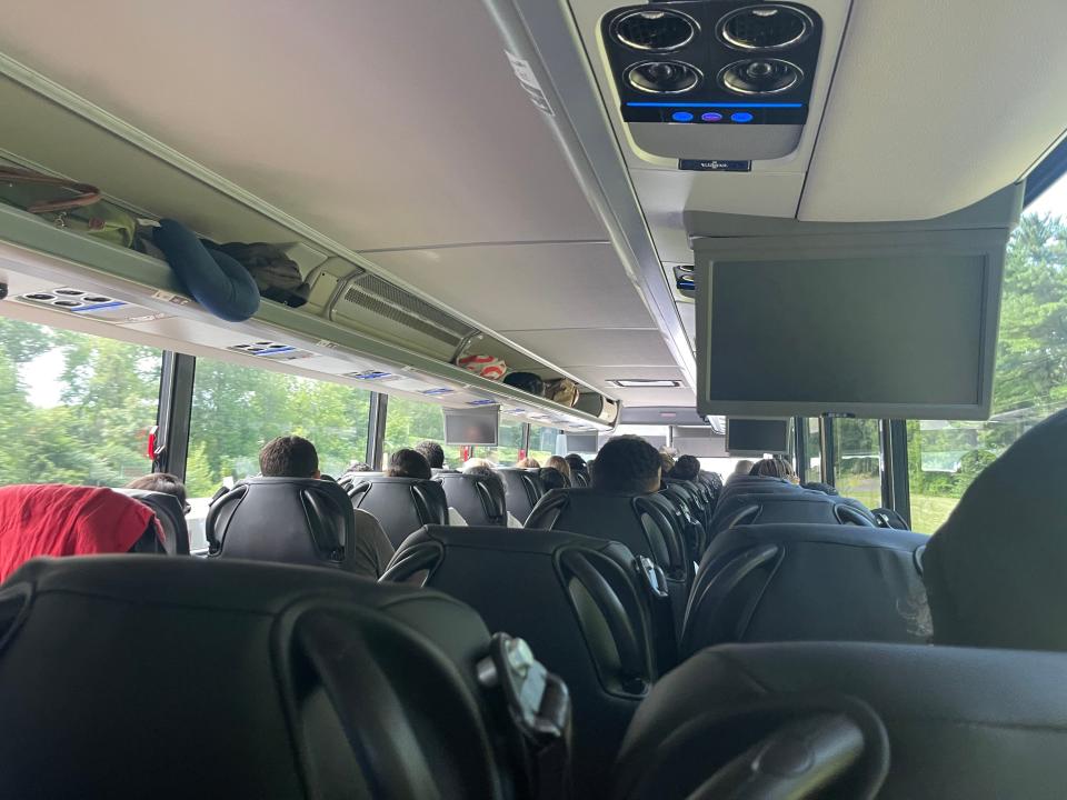 The insider of the standard coach bus, which has several people sitting in seats while riding it