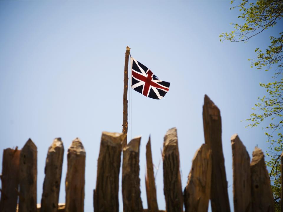 a british flag flying over wood fortress in jamestown virginia