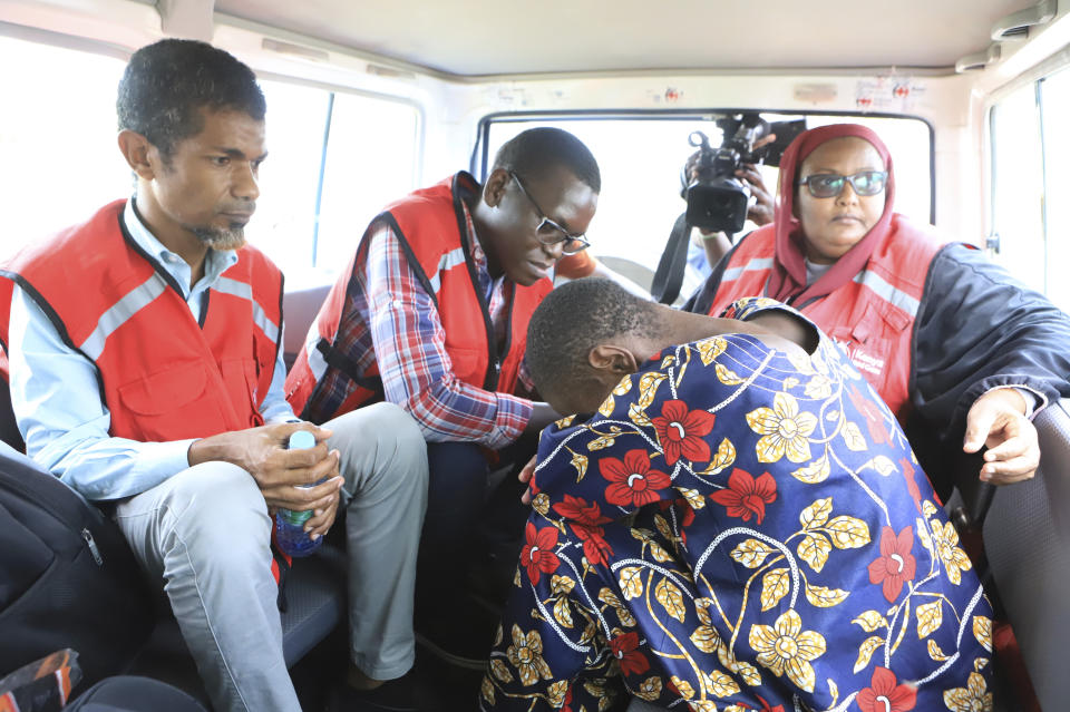 A woman, one of the followers of a Christian Cult that has killed dozens bends as she sits next to Kenya Red Cross officials inside a car after being rescued by police in a forest in Shakahola, outskirts of Malindi town, Kenyan Coast Tuesday, April 25, 2023. Kenya's president William Ruto said Monday that the starvation deaths of dozens of followers of pastor Paul Makenzi, who was arrested on suspicion of telling his followers to fast to death in order to meet Jesus, is akin to terrorism (AP Photo)