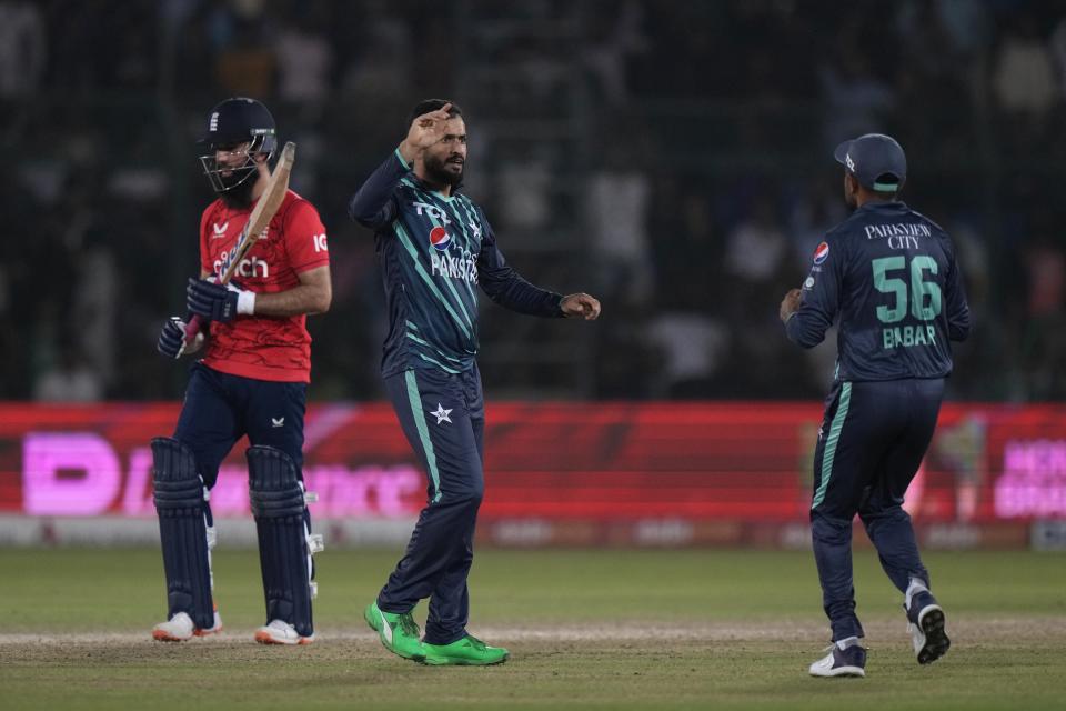 Pakistan's Mohammad Nawaz, center, celebrates after taking the wicket of England's Moeen Ali, left, during the fourth twenty20 cricket match between Pakistan and England, in Karachi, Pakistan, Sunday, Sept. 25, 2022. (AP Photo/Anjum Naveed)