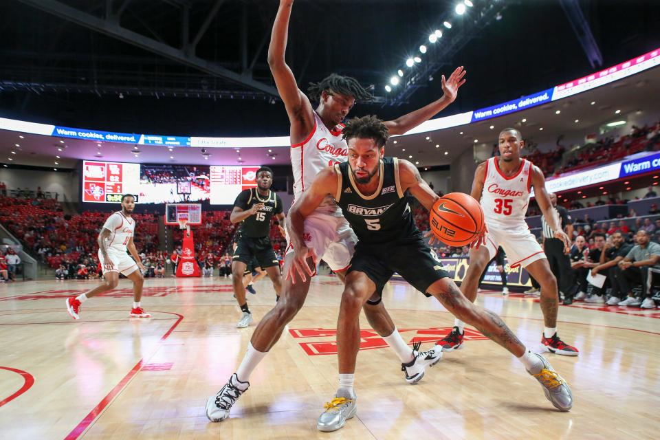 Bryant guard Charles Pride gets past Houston guard Tramon Mark during a game in Houston on Dec. 3. On Monday, Pride was named NEC player of the week.