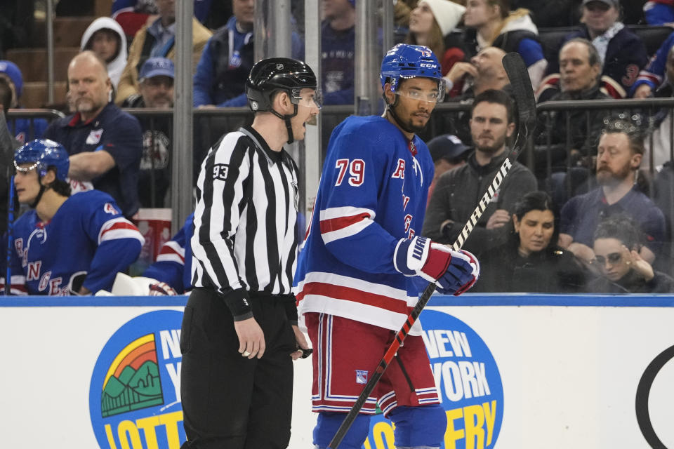 Linesman Kilian McNamara (93) escorts New York Rangers' K'Andre Miller (79) off the ice after Miller received a penalty during the first period of an NHL hockey game against the Los Angeles Kings, Sunday, Feb. 26, 2023, in New York. (AP Photo/Frank Franklin II)