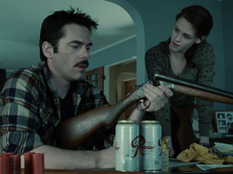 Billy Burke (Charlie Swan) cleans his gun while Bella (Kristen Stewart) watches over his shoulder in a scene from "Twilight."