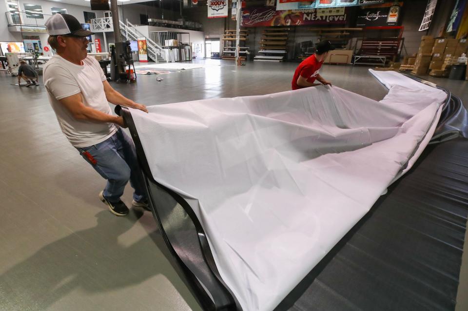 The staff at USA Image prepares the Hometown Hero banner of Jack Harlow at their facility in Jeffersontown.  The banner measures 45 feet by 70 feet.