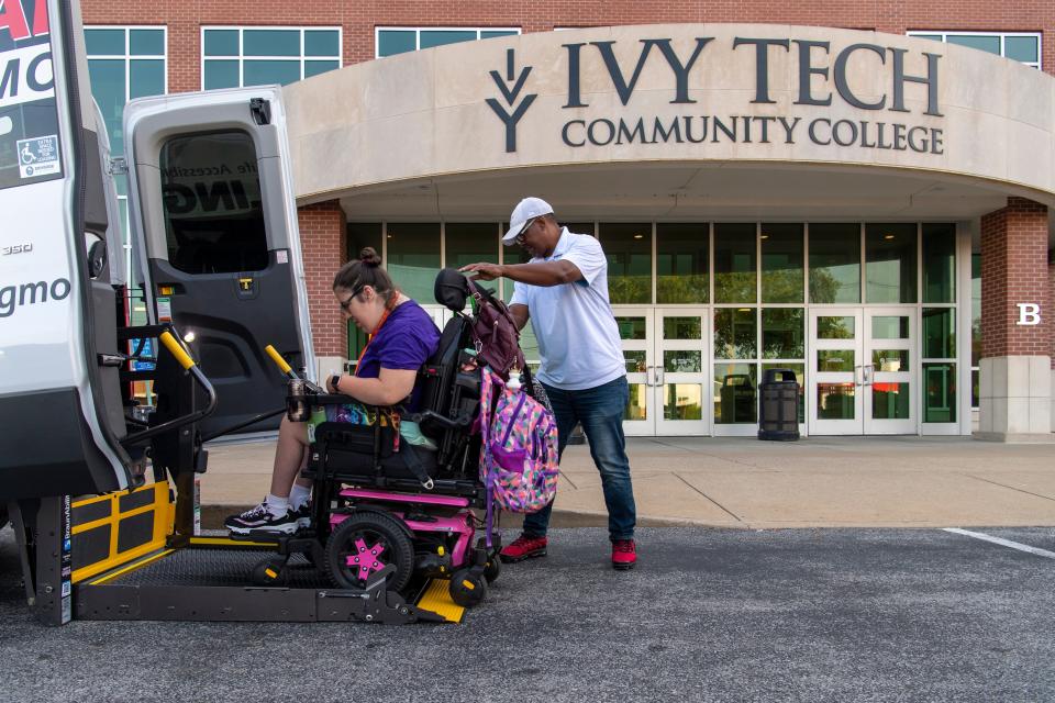 Megan Durre, left, is assisted off the Garling Mobility transport vehicle by Adrian Mockobee in front of Ivy Tech Community College Friday morning, July 14, 2023. Durre arrives on campus at 8 a.m., and hopes to leave at 4:30, but due to a shortage of drivers at METS Mobility her scheduled rides have more and more often been canceled.