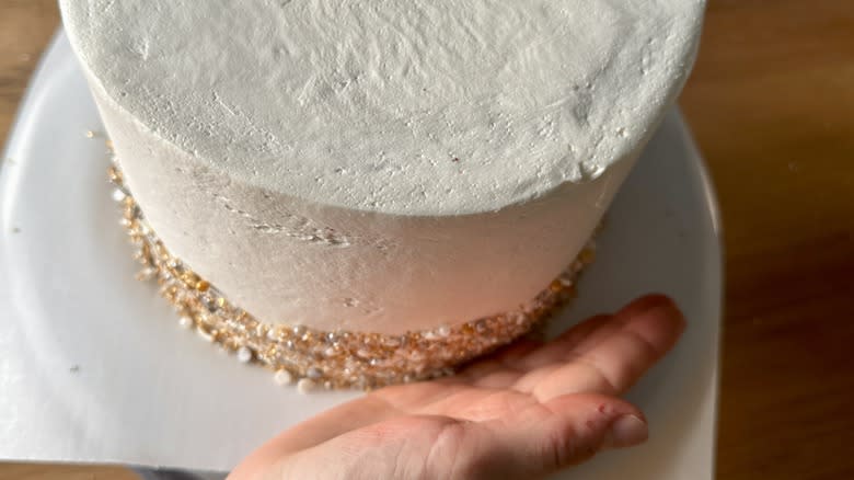 pressing sprinkles into cake sides