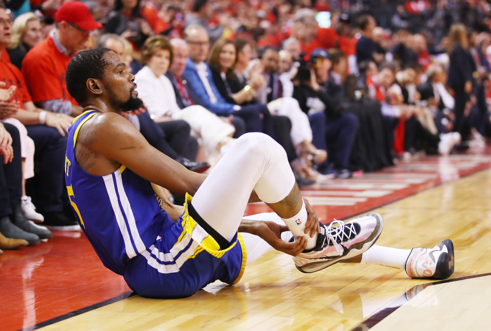 TORONTO, ONTARIO - JUNE 10:  Kevin Durant #35 of the Golden State Warriors reacts after sustaining an injury during the second quarter against the Toronto Raptors during Game Five of the 2019 NBA Finals at Scotiabank Arena on June 10, 2019 in Toronto, Canada. NOTE TO USER: User expressly acknowledges and agrees that, by downloading and or using this photograph, User is consenting to the terms and conditions of the Getty Images License Agreement. (Photo by Gregory Shamus/Getty Images)