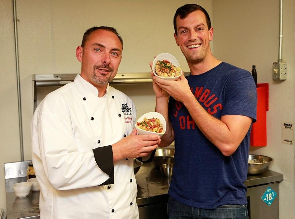 Two men holding potato salad