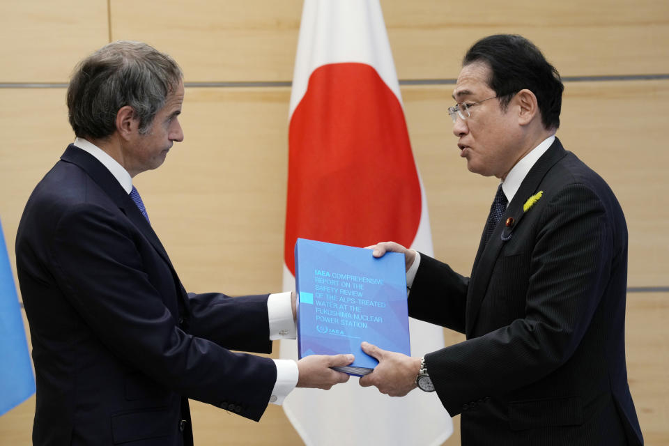 Rafael Mariano Grossi, Director General of the International Atomic Energy Agency, left, presents IAEA's comprehensive report on Fukushima Treated Water Release to Japanese Prime Minister Fumio Kishida, right, at the prime minister's office Tuesday, July 4, 2023 in Tokyo. (AP Photo/Eugene Hoshiko, Pool)